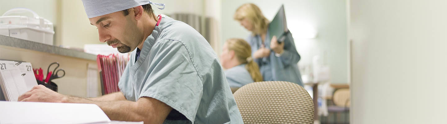 enfermera sentada en la estación de enfermería haciendo papeleo