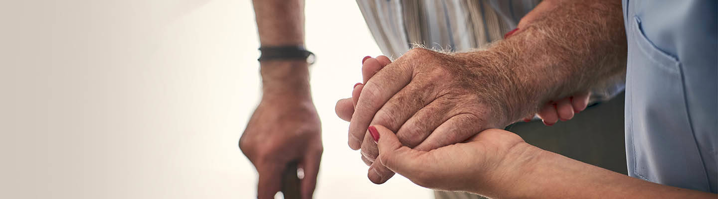 enfermera sosteniendo la mano de un anciano