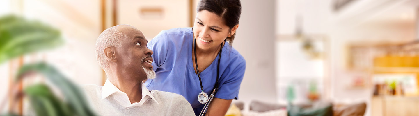 Trabajador de la salud sonriendo a un paciente mayor