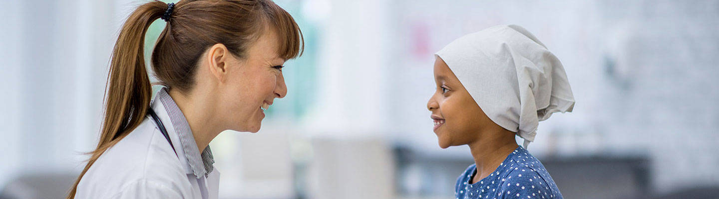 Una oncóloga infantil visita a su paciente.