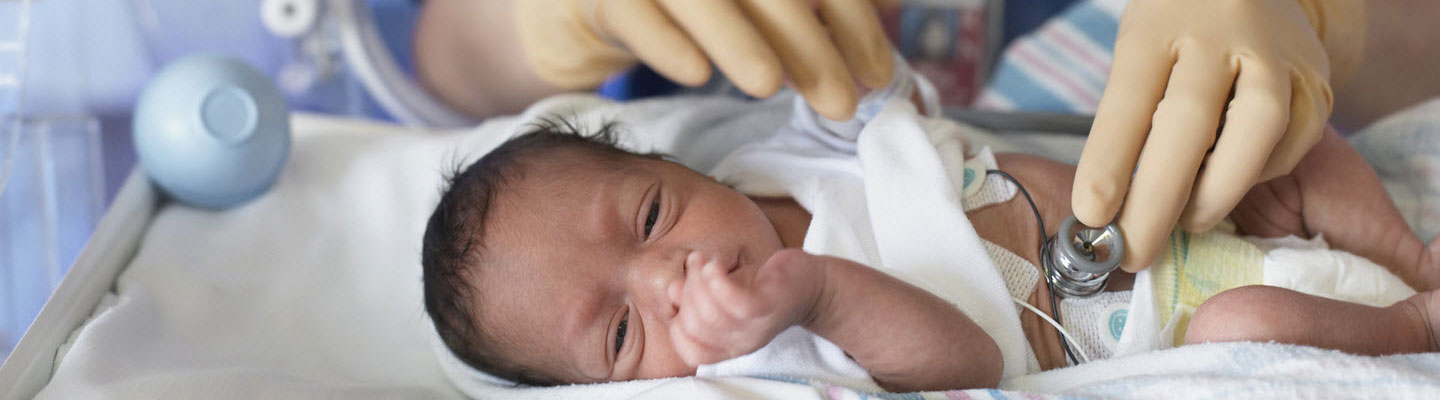 Doctor examina recién nacido en incubadora