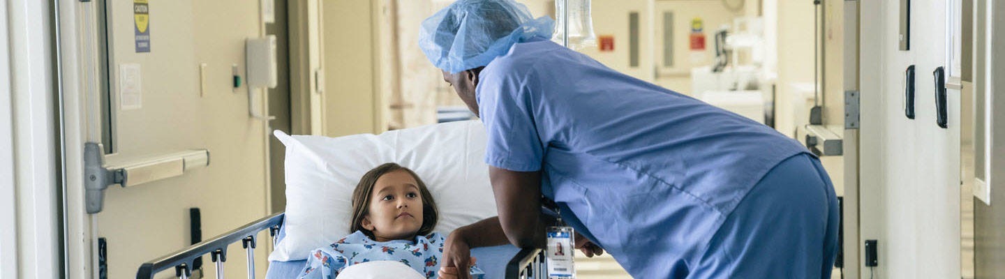Doctor sosteniendo la mano de una chica en la camilla del hospital.