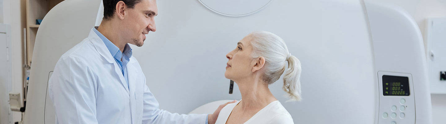 Un paciente y su cuidador cerca de una máquina de resonancia magnética.