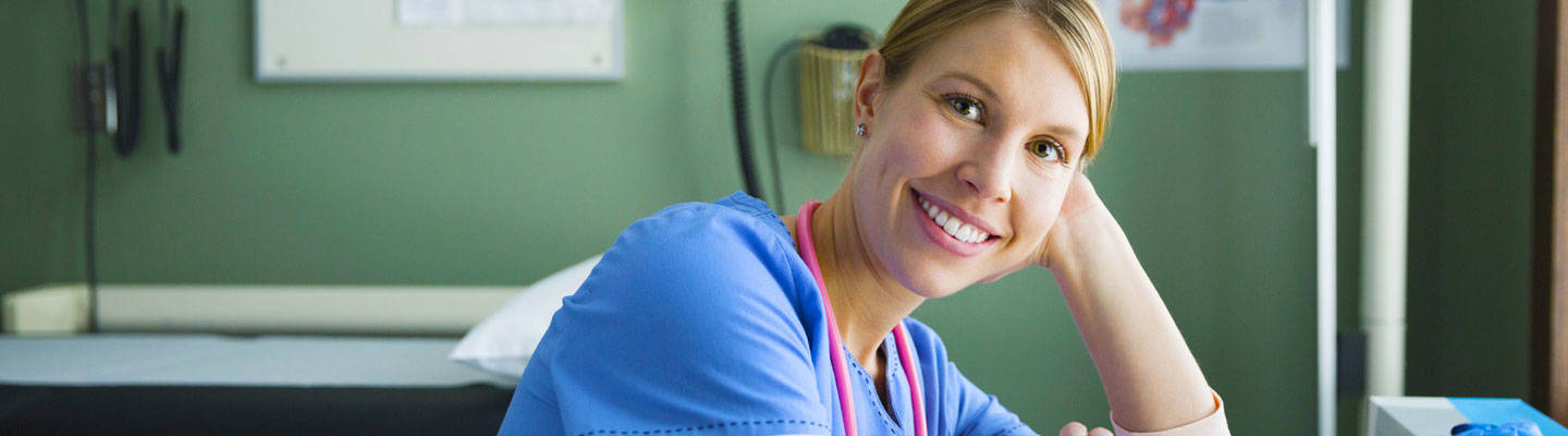 Enfermera feliz sonriendo en el consultorio del médico