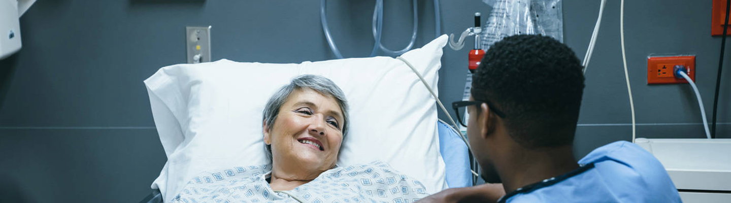 Enfermero con paciente mayor tendido en la cama del hospital