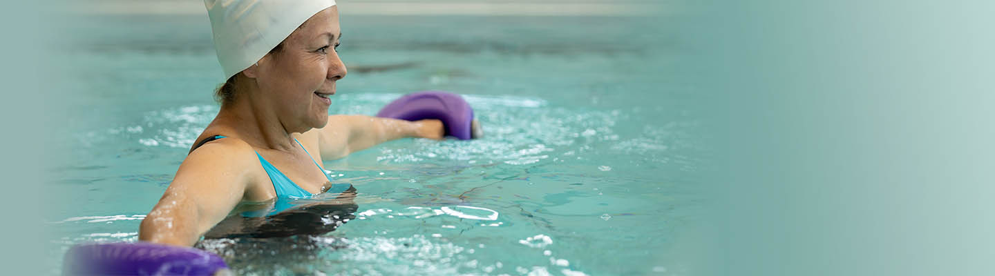 mujer en piscina sosteniendo pesas