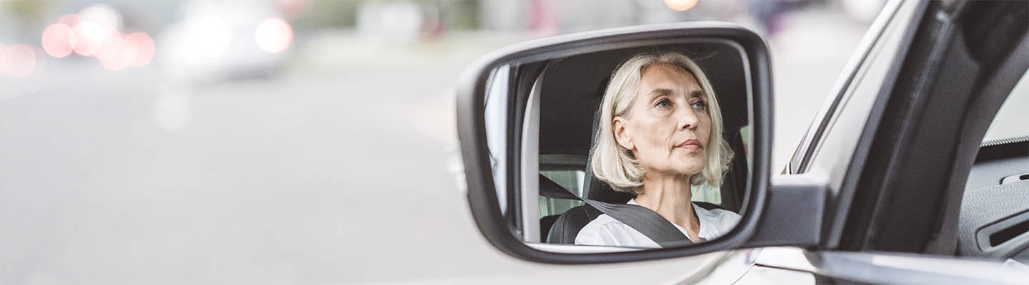 reflejo de la mujer en el espejo retrovisor lateral del coche