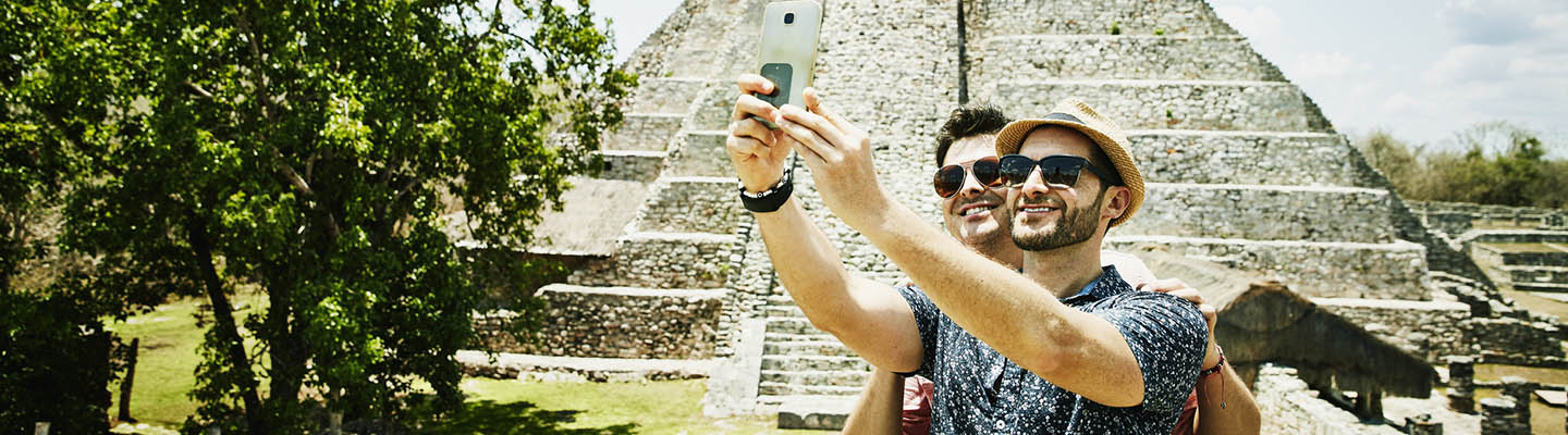 2 hombres sonrientes tomando selfie en las ruinas de Mayapan