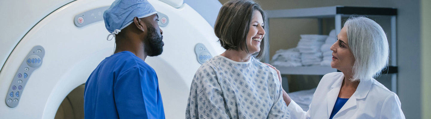 Paciente sentado en una máquina de resonancia magnética con médicos