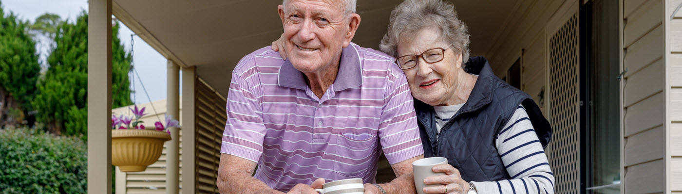 Pareja de ancianos bebiendo café en su porche